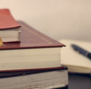 Stack of legal books and a pen for vital record corrections