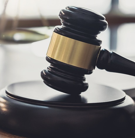 Judge’s gavel and a person signing legal birth certificate