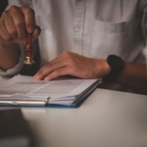 Hand using a seal to notarize a death certificate document