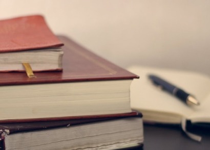 Stack of legal books and a pen for vital record corrections