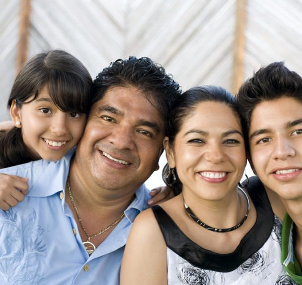 Smiling family of parents with their two children representing parentage declaration