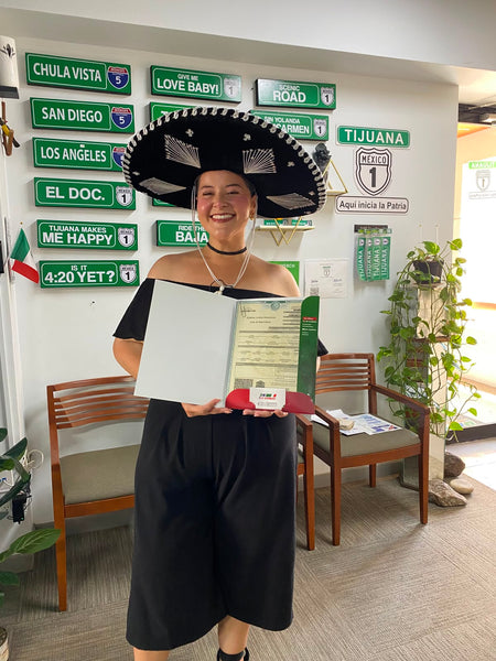 Happy DNExpress client holding her Mexican birth certificate after obtaining dual citizenship in Tijuana office