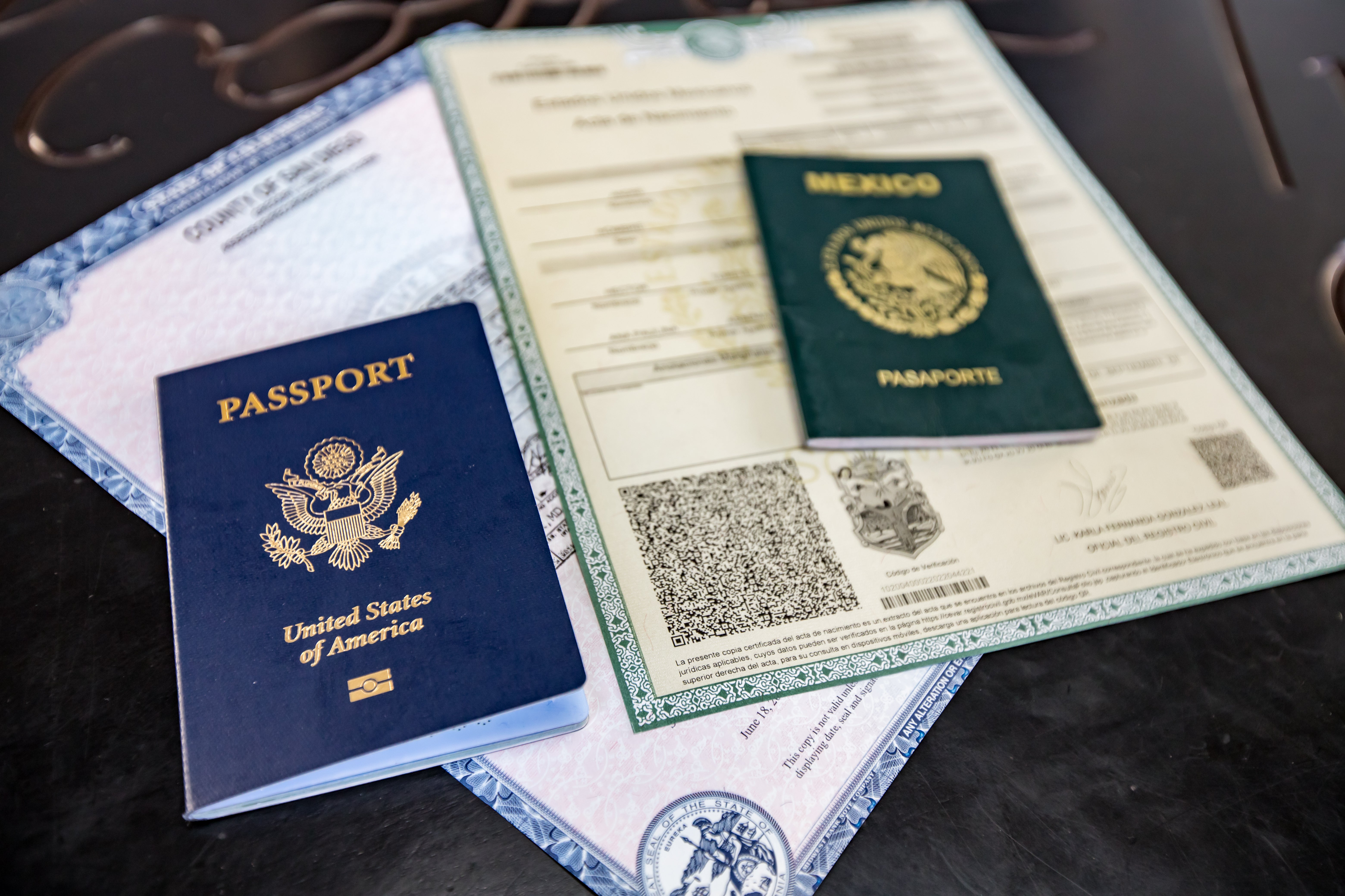 Acta de nacimiento y pasaporte mexicano sobre escritorio mostrando documentos requeridos para probar ciudadanía por bisabuelos
