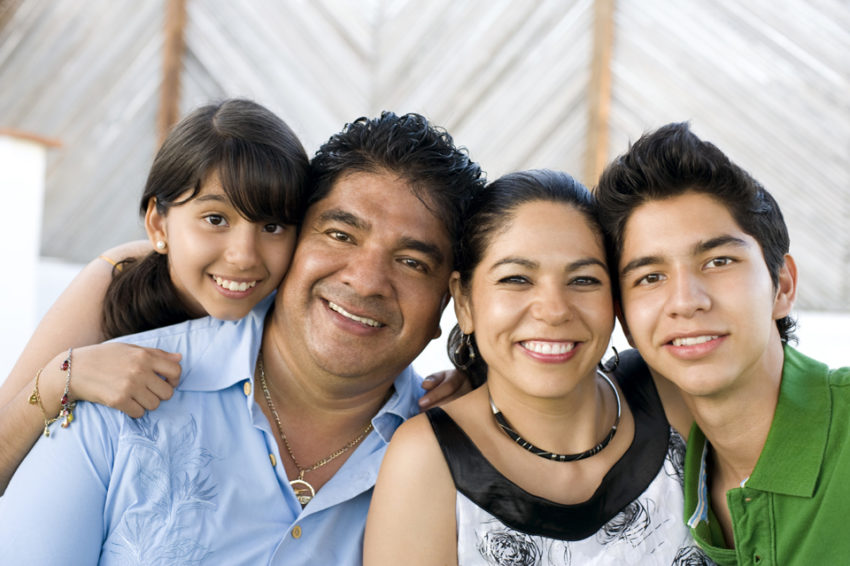 Familia sonriente de padres con sus dos hijos representando la declaración de paternidad